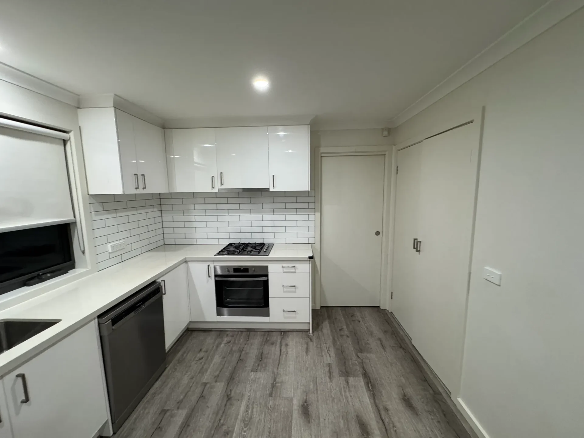 Complete kitchen renovation with white cabinets and timber flooring