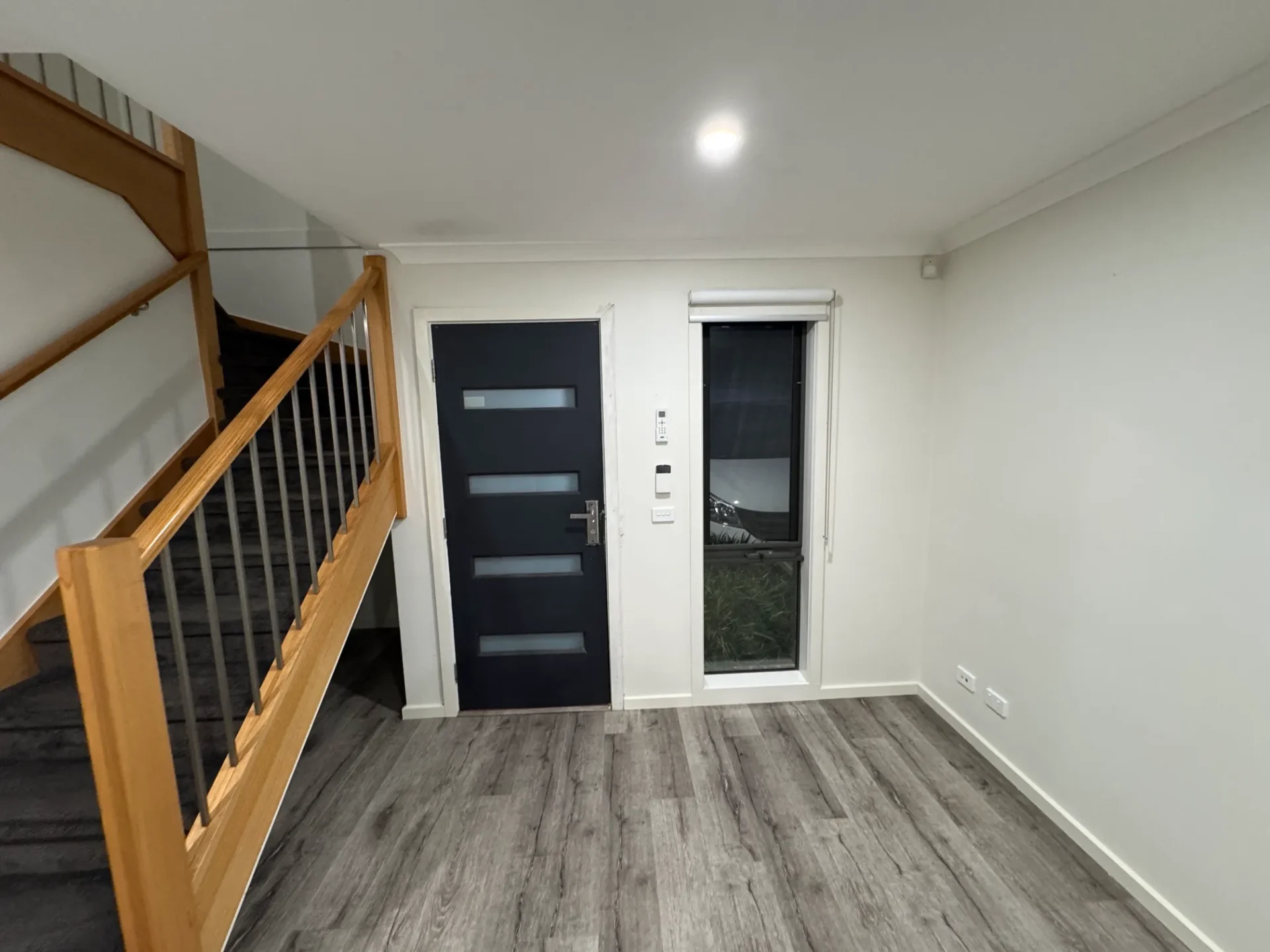 Modern entryway with black door and timber flooring