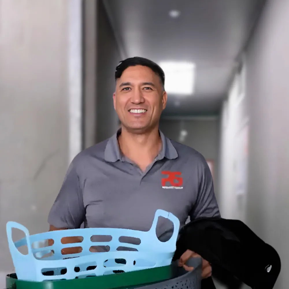 Professional technician tidying a rental property hallway in clean uniform